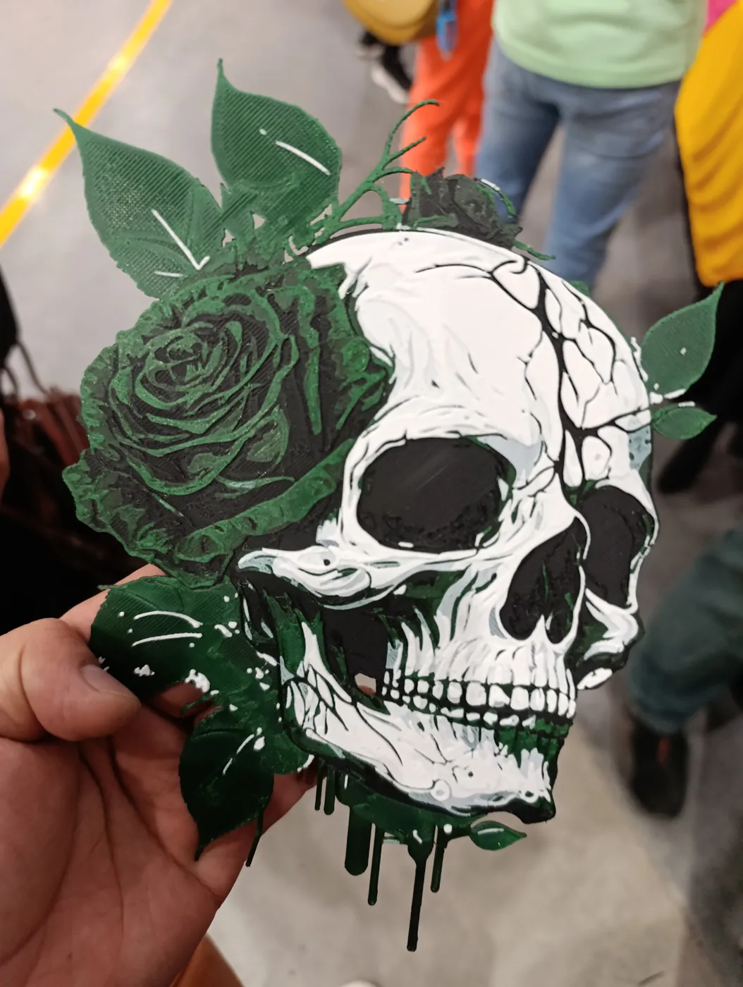 Pieza decorativa de calavera con rosas y hojas en blanco, negro y verde